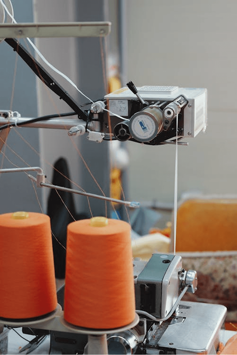 Cone-dyed cotton yarn beside a knit sewing machine